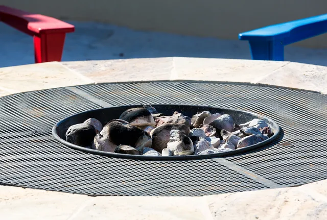 Modern fire pit with seating on a stone patio