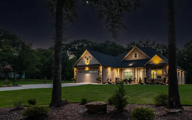 Foundation planting beds lit by low-voltage landscape uplighting at night