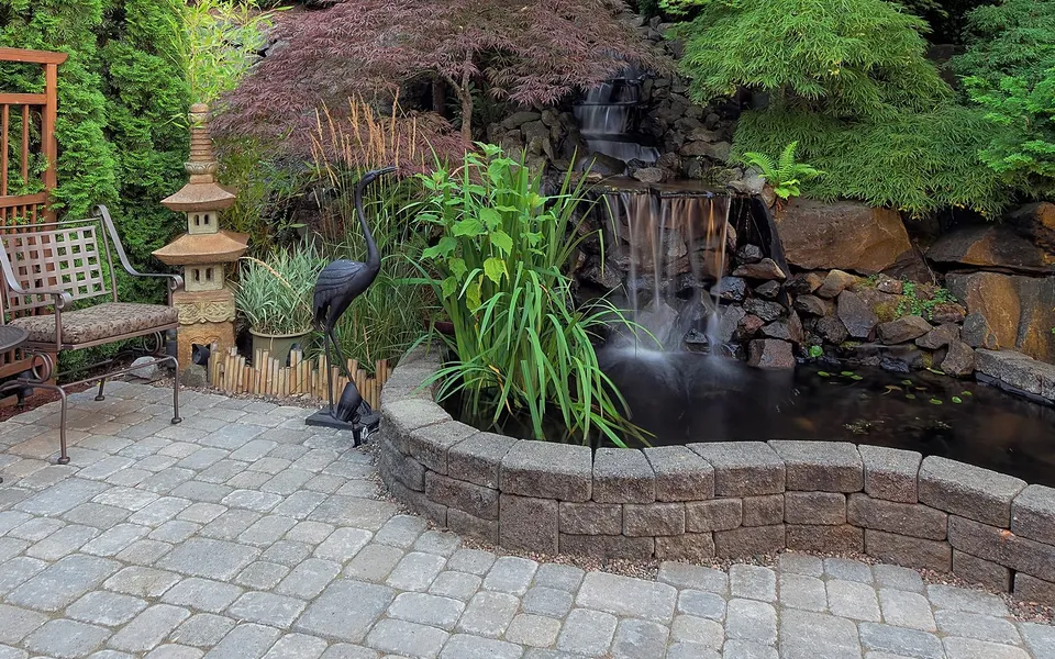 Lush layered Florida garden with tropical planting around a pond