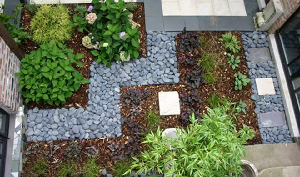 Layered planting bed with river rock accents seen from above